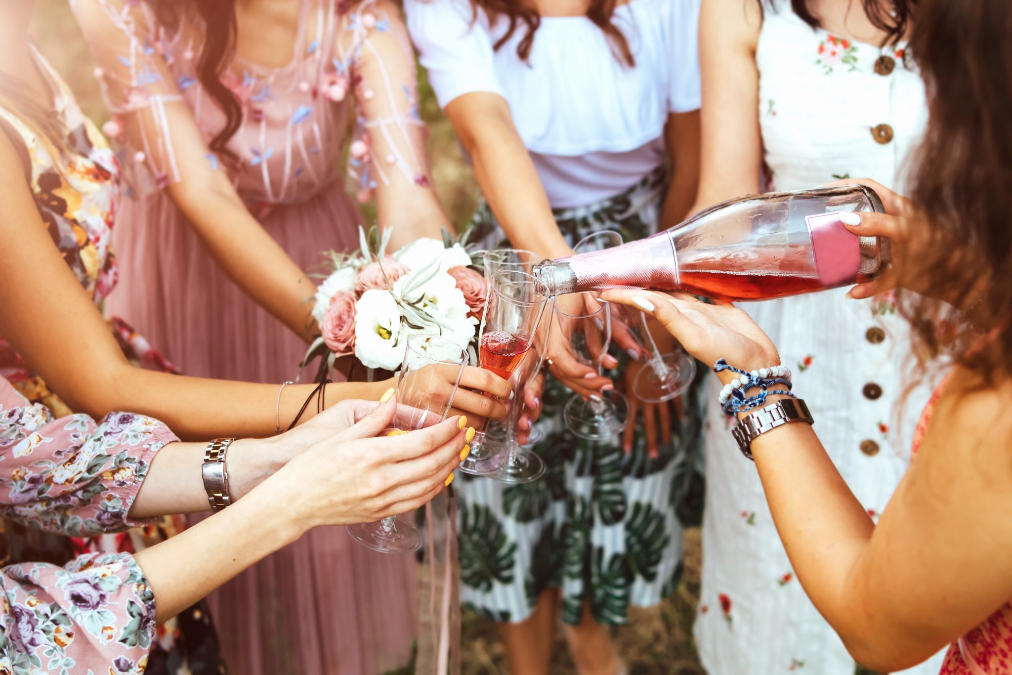 Champagne with glasses in girls hands at hen / bachelorette party outdoor