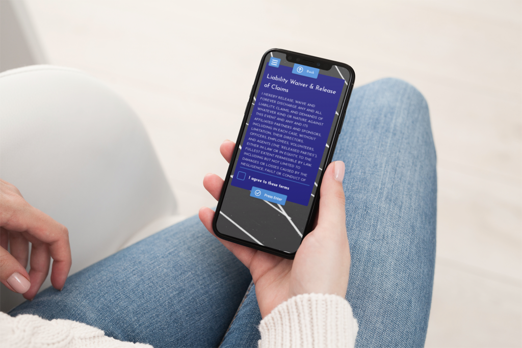 Woman holding iPhone with branded event liability waiver terms. 